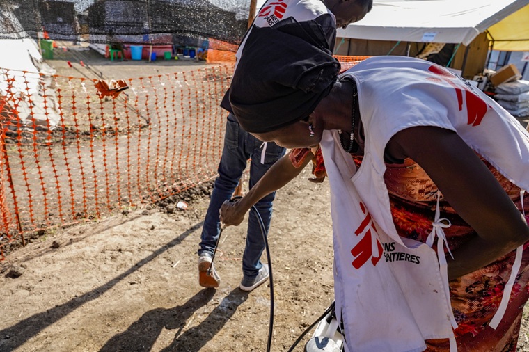 南スーダンのコレラ治療センターに出入りする人びとを消毒するMSFスタッフ=2024年11月26日 © Paula Casado Aguirregabiria