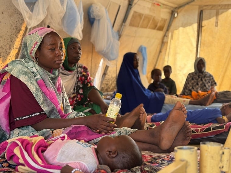 国境なき医師団(MSF)がスーダンの中央ダルフール州ロケロに設置した隔離病棟で、はしかの子どもと共に過ごす母親たち=2025年5月11日 © Thibault Fendler/MSF