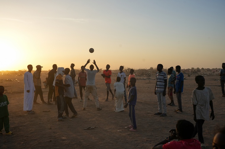 ティネの一時滞在キャンプで夕暮れ、集まってバレーボールをする子どもたち。現地の日中の気温は日陰でも46度に達する=2025年6月11日 Ⓒ Julie David de Lossy/MSF