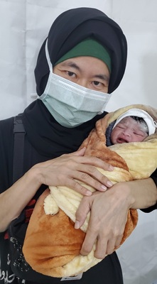 アブス病院で生まれたばかりの赤ちゃんを<br> 抱っこする濱川＝2022年　Ⓒ MSF