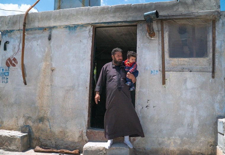 末の息子を抱くワリードさん © Ahmad Amer/MSF