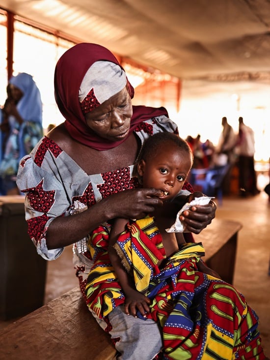 現地の医療施設にて孫を抱き抱える祖母　Ⓒ Abba Adamu Musa/MSF