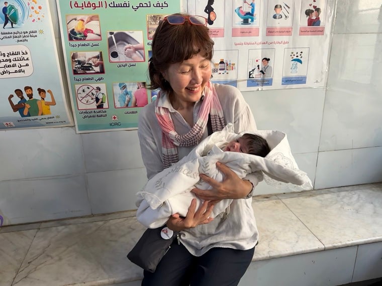 現地で赤ちゃんを抱く錦織 © MSF