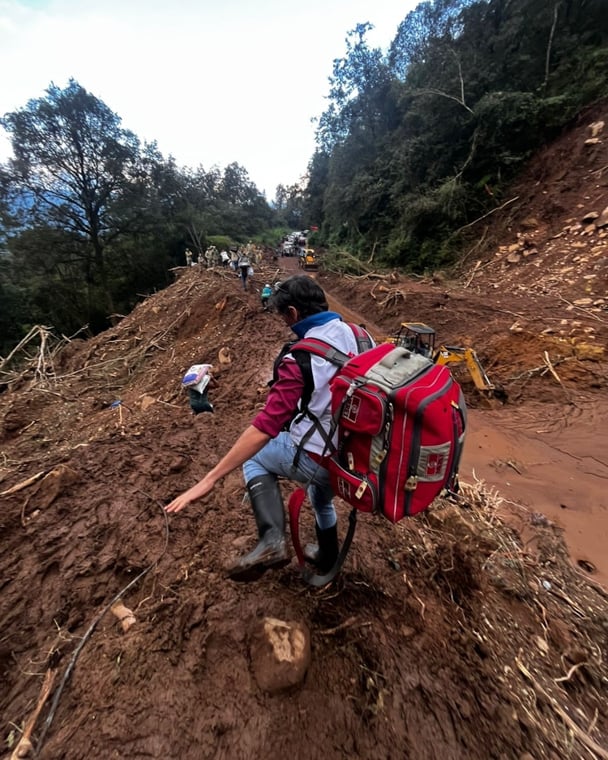 土砂崩れが起きたイダルゴ州の山間地域。孤立集落へ向かうため、MSFスタッフが医療機器を背負って渡っている=2025年10月17日 Ⓒ MSF