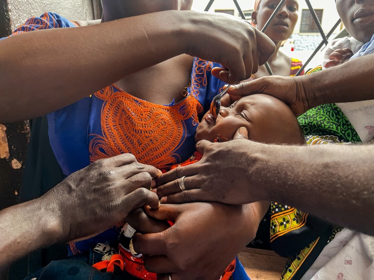 子どもにマラリアの予防薬を飲ませる母親=2025年5月15日 © Dorine Niyungeko/MSF