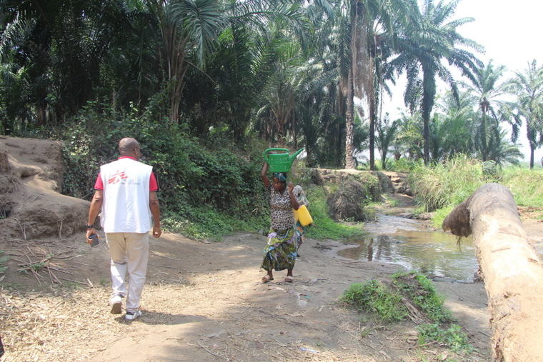 消毒する水がある地点を巡視するMSFの水・衛生担当者(左)。現地では住民(右)が川から水をくんで運ぶ=南キブ州フィジで2025年10月13日 Ⓒ Abdon MANENGU Mbangala/MSF