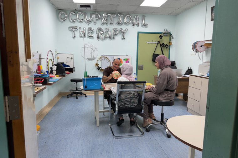 MSFの作業療法士（中央奥）と一緒にボールを押し引きして、リハビリに励む女性の患者（中央手前）＝アンマンの再建外科病院で2025年10月26日　Ⓒ MSF