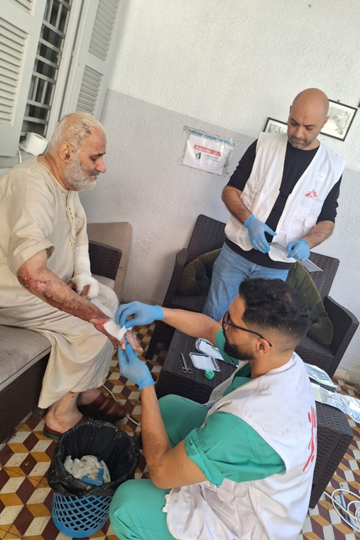 空爆で重度のやけどを負った男性に包帯を巻くMSFの看護師ムハンマド（手前）＝ガザのMSFやけどクリニックで2023年10月19日　Ⓒ MSF