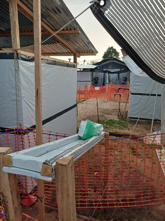 グリーンゾーン（手前側）からレッドゾーン（奥側）へは、木製の滑り台を使って物資を渡していた＝ブラぺ保健区域のエボラ治療センターで2025年10月12日　Ⓒ MSF