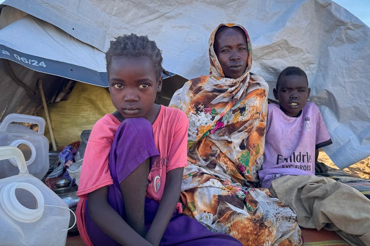 エル・ファシールから2人の子どもと逃れてきた母親IOさん（左から2人目）。夫は家族のために食料を探していた際、砲撃に巻き込まれて死亡した＝ダバ・ネイラキャンプで2025年11月9日　Ⓒ Natalia Romero Peñuela/MSF