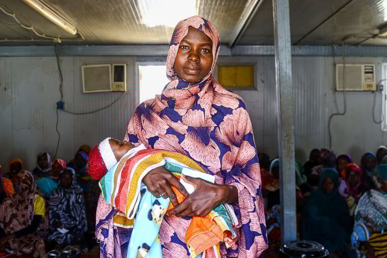 スーダン／南ダルフール州：カルマの避難民キャンプで生まれたばかりの第一子を抱くリハブ・ムサさん。MSFが運営する診療所で診察を受けた＝2024年12月　© Abdoalsalam Abdallah