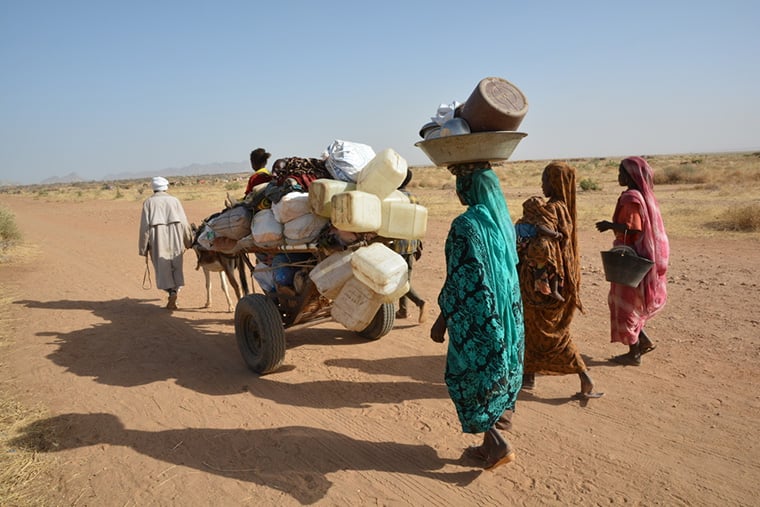 スーダン／北ダルフール州：タウィラ周辺で続く紛争により、所持品を抱えて避難を余儀なくされた一家＝2025年4月　© Jérôme Tubiana