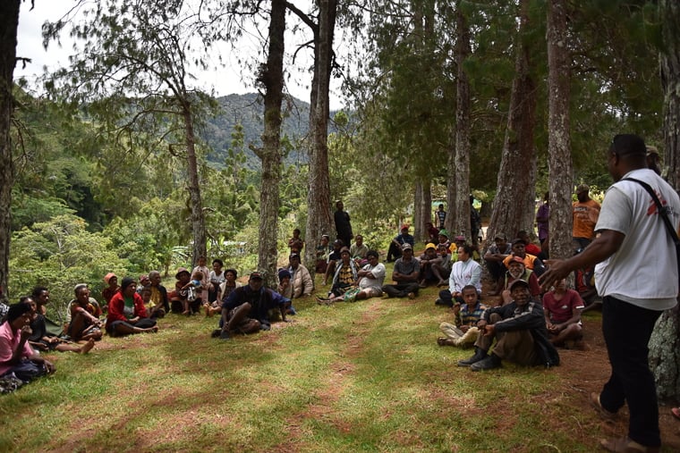 パプアニューギニア／ジワカ州モンドゥミル村：暴力の被害者に対する医療体制を強化するため、MSFの健康推進チームが住民に話をしている＝2025年2月　© Sophie