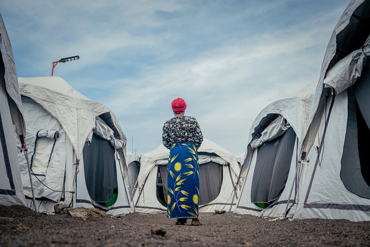 コンゴ民主共和国・北キブ州：ゴマのムグンガ3診療所で、性暴力の被害者や生存者の治療や女性の健康問題へのケアのために設置されたテントの間に、女性患者が立つ＝2025年7月　© Jospin Mwisha