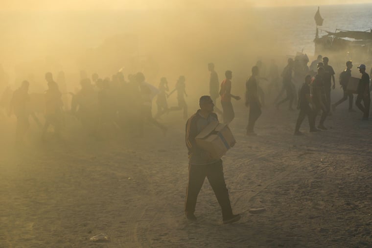 パレスチナ・ガザ地区ネツァリムの「ガザ人道財団（GHF）」の配給所で支援物資を手に歩く男性　© MSF