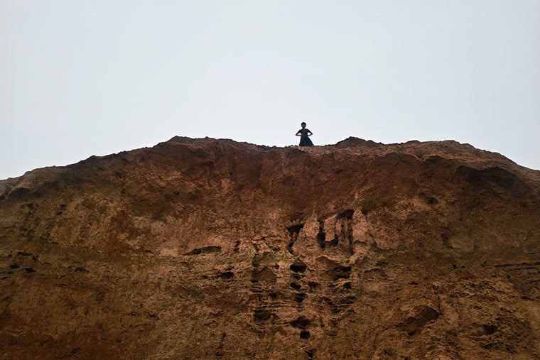 バングラデシュ／コックス・バザール：クトゥパロン難民キャンプの丘の上に立つ子ども。ここではモンスーンによる豪雨や洪水の影響で地滑りが発生した。かつて避難所が建てられていたが、地滑りによって失われ、今では危険なまま放置され、人が住むことはない＝2025年6月　© Sahat Zia Hero