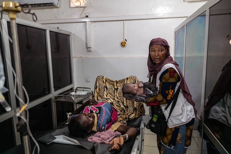 スーダン／西ダルフール州：ジェレイナ教育病院で、出産をサポートしたMSFの助産師メスケレム・ムルゲタ。生まれたばかりの赤ちゃんを抱く＝2025年8月　© Moises Saman/Magnum Photos