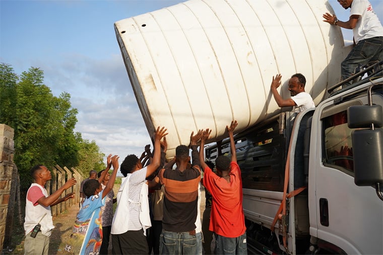 エチオピア・ティグレ州：シェラロの避難民キャンプで、MSFのスタッフと地元住民が給水タンクを設置している。2020年11月に始まった2年間にわたる紛争により、数千人が避難を余儀なくされ、この地域は深刻な被害を受けた＝2025年7月　© Roza Bekele/MSF