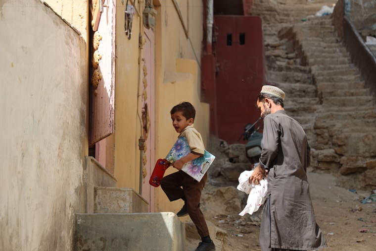 父ラヒムさんとともに、学校から帰って来たムスタファくん。今は元気に学校に通っている＝2025年11月5日　© Gul Nayab/MSF