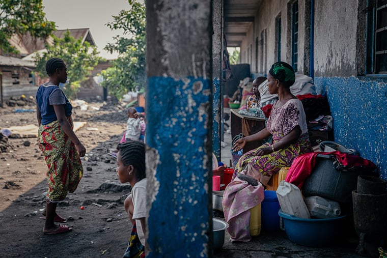 ゴマにある学校の外で子どもと一緒に座る女性たち。中には性暴力を受けた被害者もいる＝2025年6月27日　© Jospin Mwisha