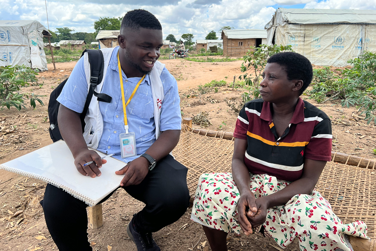 ムエダ近郊の避難民キャンプで、7人の子と共に故郷から逃れた母親（右）と話をするMSFスタッフ＝2025年11月11日　© Igor Barbero/MSF