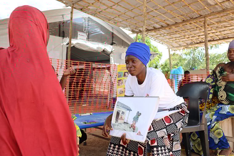 カーボ・デルガード州メトゥゲ郡ナンリア村で、患者に対してコレラ感染予防の啓発をするMSFスタッフ（右）＝2025年12月10日　© MSF