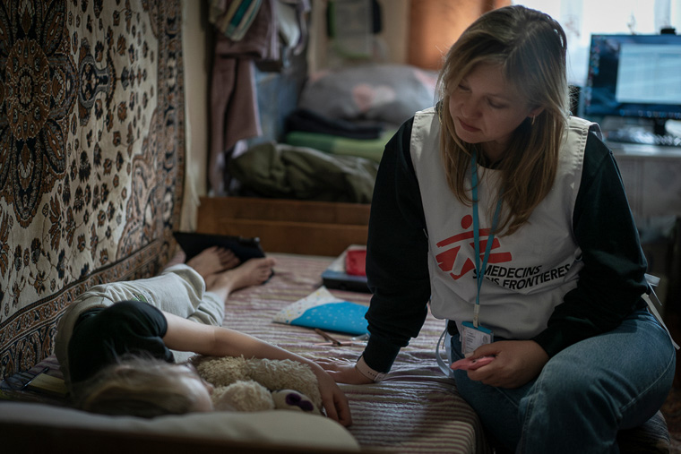 ウクライナ東部のドネツク州を離れ、ビンニツァの避難民施設に身を寄せる10歳の少女（左）。MSFの心理療法士が訪れて声をかけている＝2025年4月2日　© Caroline Thirion