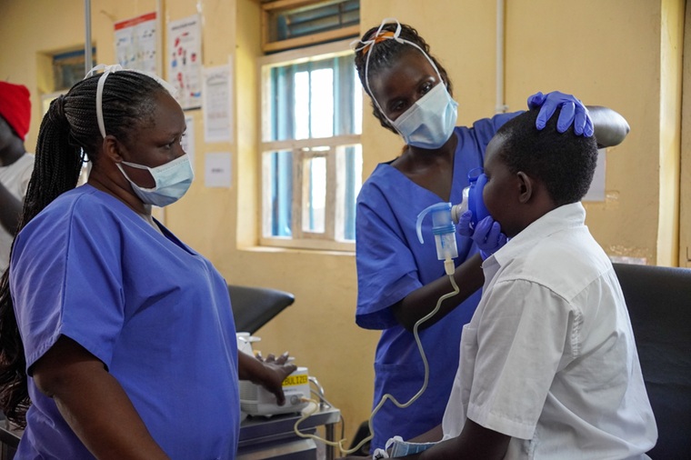 チューター（先生役のスタッフ）に見守られながら、患者に薬を投与する看護スタッフ（右）　© Alicia Gonzalez/MSF