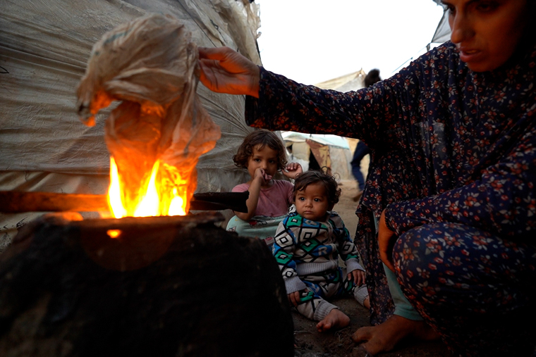 重い呼吸器疾患を抱える男の子（生後7カ月）の母親。「服がないため仕方なくビニール袋を着せるが、そのせいで皮膚の感染症や発疹に悩まされる」と話す＝2024年11月7日　©  Ibrahim Nofal
