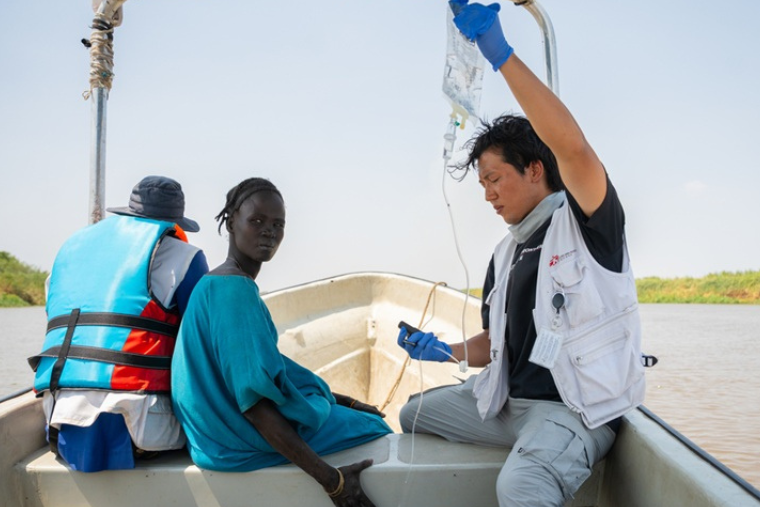 患者をボートで搬送しながら、点滴治療を行うMSFスタッフ＝2026年3月12日　© Isaac Buay/MSF