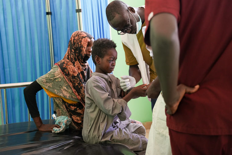 内戦に巻きこまれて左手を失い、病院で手当てを受けるスーダンの少年　© Julie David de Lossy/MSF