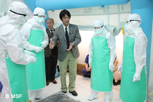 防護服を着用した医療者にエボラ対策の作業を説明する加藤副会長