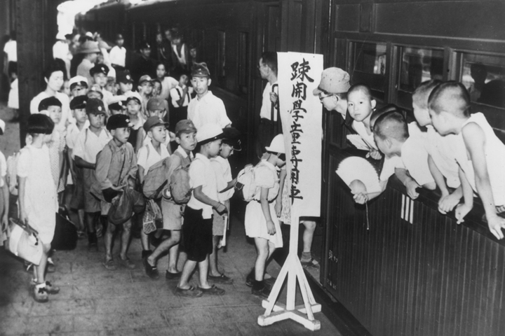 児童疎開の専用列車に乗り込む子どもたち。空襲で街は焼き尽くされ、食べるものが手に入らない日々。疎開すれば腹いっぱいご飯が食べられる、そう信じて親元を離れていった。