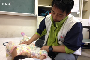 白水仮設診療所で腹痛の女の子を診察する医師