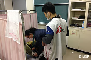 夜間、体調不良を訴えた患者に対応する医師と看護師4月21日、白水仮設診療所にて