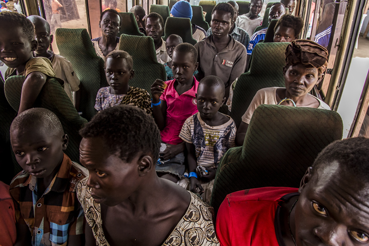 バスに乗っているのは南スーダン各地から逃れてきた人びと。ウガンダ国境で保護され、食事の提供を受けたあと、バスでキャンプの受付へと送られる。国境から数時間の道のりを経て、彼らは「難民」となる。
