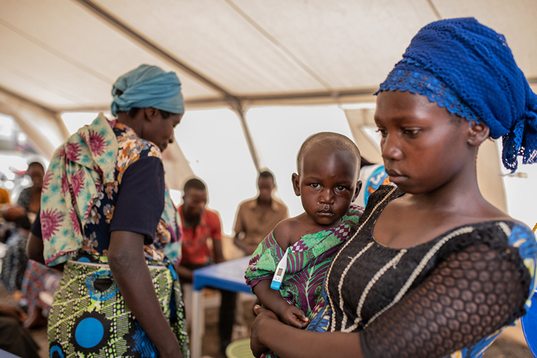 高熱を出した娘を連れて、カニャルチニャ診療所を訪れた女性。MSFはここで無償の診療と適切な治療を提供している　Ⓒ Moses Sawasawa