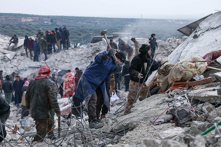 シリア北西部イドリブ県、地震で倒壊した建物のがれきの中で救助活動をする人びと＝2023年2月6日　© Omar Haj Kadour