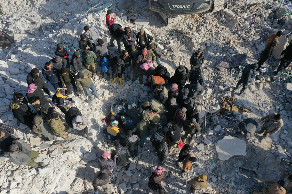 シリア北西部イドリブ県、地震で倒壊した建物のがれきの中で救助活動をする人びと＝2023年2月7日　© OMAR HAJ KADOUR 