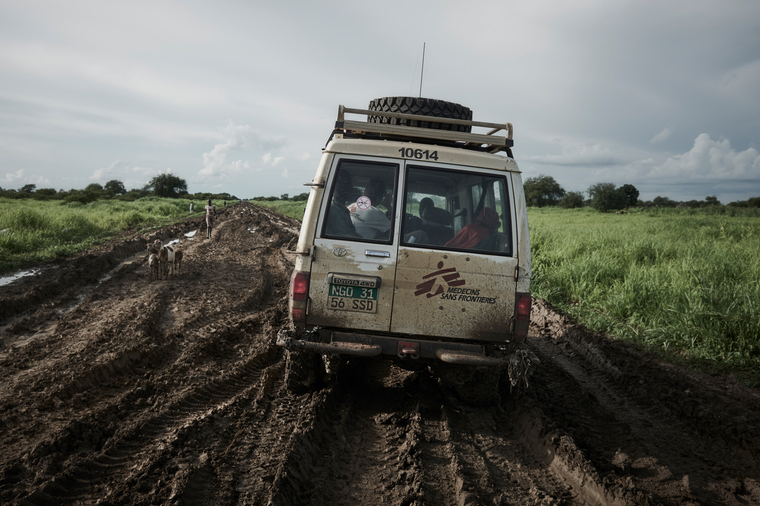 患者を乗せ、舗装されていない南スーダンの泥道を走るMSFの車　© Christina Simons