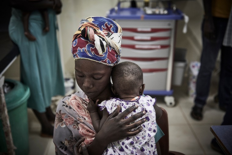 南スーダン北部、生後4カ月の娘がマラリアを患い、MSFの支援先病院を訪れた女性（19歳）　© Christina Simons