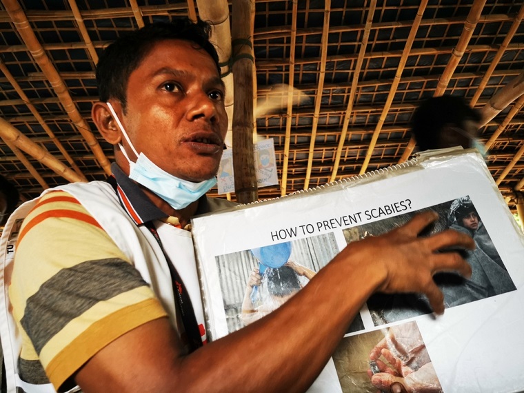 疥癬の感染方法や治療の仕方を写真や絵を使って説明する　© MSF/Malvoisin