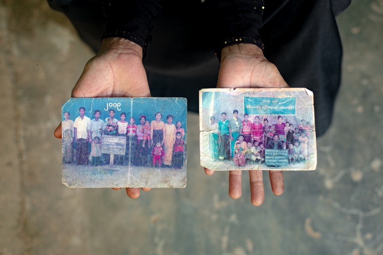 色あせて擦り切れた、ミャンマー時代の家族写真。子と孫に囲まれたメルアさんの姿が写っている