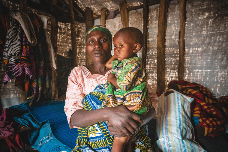 避難地域のテント内で娘を抱えるシファさん © MSF/Laora Vigourt