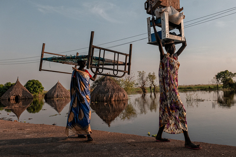 浸水地域で家財道具を運ぶ © Sean Sutton