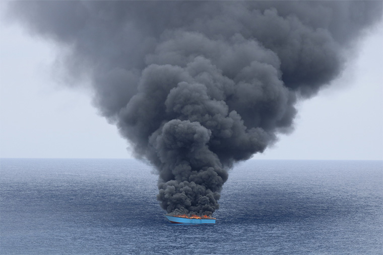 地中海：リビア沿岸警備隊に捕らえられた木造船から黒煙が上がる。木造船には約50人が乗っていたが、火が放たれる前に沿岸警備隊の船に移された＝2023年6月　Ⓒ MSF/Skye McKee