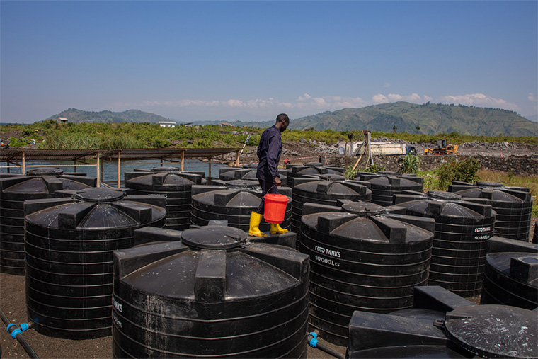コンゴ民主共和国：北キブ州ゴマの国内避難民キャンプにある、水の貯蔵と処理に使用されるタンク。その上をMSFの水と衛生管理の専門家が歩く＝2023年7月　Ⓒ MSF/Alexandre Marcou