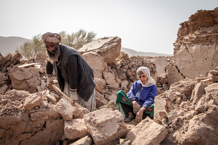 アフガニスタン：3度に及ぶ強い地震に襲われた西部ヘラート。地震が発生してから5日後、自宅だった場所のがれきを掘り起こすアブドルサラームさん（左）とそれを見守る母親＝2023年10月　Ⓒ Paul Odongo/MSF