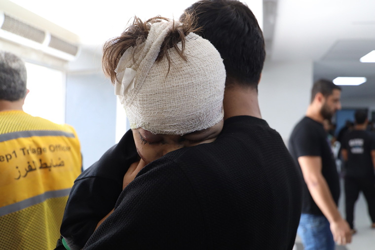 パレスチナ・ガザ地区：父親と抱き合う少年。空爆で負傷した後、北部のシファ病院で治療を受けた＝2023年10月　Ⓒ Mohammad Masri