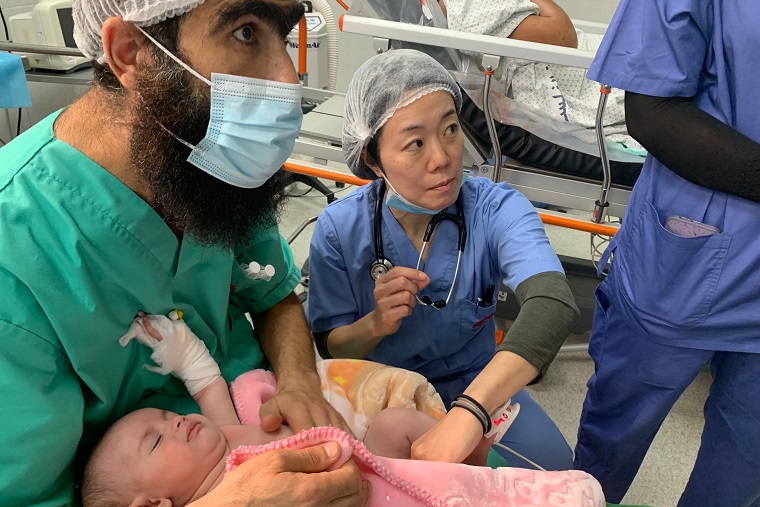 ガザ南部・ナセル病院の手術室で術後の重傷乳児を診る中嶋=11月20日 © MSF